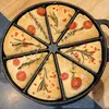 A cast iron pan with 8 sections, each filled with a slice of focaccia bread topped with cherry tomatoes, rosemary, and red pepper flakes. Produktbild-Vorschau