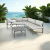 An outdoor seating group with a sectional sofa and coffee table on a patio overlooking the ocean. Voir les images du produit