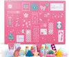 A pink advent calendar with numbered doors and various festive illustrations, with some of the advent calendar's contents displayed in front of it. Podgląd zdjęcia produktu