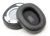 Two black headphone ear pads are shown on a white background. One ear pad is detached and shows the inner workings, while the other is intact. Produktbild-Vorschau