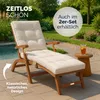 A wooden lounge chair with a beige cushion is placed on a patio next to a small side table with a drink. Produktbild-Vorschau