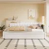 A modern bedroom with a white daybed, decorated with pillows and a throw blanket. A painting hangs on the wall, and a floor lamp stands in the corner. Náhled obrázku produktu