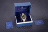 A gold Maserati chronograph watch is displayed in its blue velvet-lined presentation box, with accompanying Maserati branded cards on a textured black surface. Náhled obrázku produktu