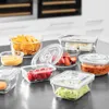 A collection of glass food storage containers filled with various foods, arranged on a countertop. Produktbild-Vorschau