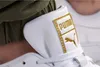 A close-up shot of the Puma logo on a white sneaker, with a green garment in the background. Produktbild-Vorschau