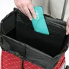 A person's hands are shown placing a teal-colored item into a red and white checkered shopping trolley. Produktbild-Vorschau