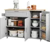 A kitchen island with storage, including cabinets, shelves, and a drawer, filled with kitchenware and food items. Náhled obrázku produktu