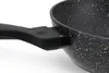 A close-up view of the handle and rim of a black frying pan with a speckled interior. Produktbild-Vorschau