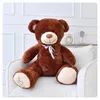 A large brown teddy bear sitting on a white armchair. Podgląd zdjęcia produktu