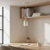 A modern desk setup with a pendant light, books, a plant, and a cup of coffee. Náhled obrázku produktu
