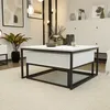 A modern living room with a white coffee table with a drawer, a plant, and decorative items. Produktbild-Vorschau