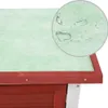 A close-up view of the roof of a red wooden rabbit hutch, showing a green waterproof layer with water droplets on it. Náhľad obrázku produktu