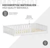 A white wooden children's bed with safety rails, shown from a slightly elevated side angle. Text overlays highlight material quality and ease of setup. Produktbild-Vorschau