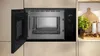 An open built-in microwave in a modern kitchen setting, with kitchen counters and decor visible. Náhľad obrázku produktu