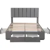 A grey upholstered bed frame with a slatted mattress base and four drawers, shown from the front. Produktbild-Vorschau