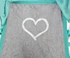 A close-up view of a grey fabric with a white heart design and teal trim. Produktbild-Vorschau