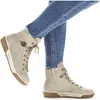 A pair of beige high-top sneakers worn by a person in blue jeans. Voir les images du produit