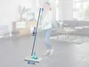 A woman is holding a mop in a living room. Anteprima dell’immagine prodotto