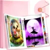 A pink binder filled with diamond painting pages, showcasing two completed diamond art pieces: a cute hedgehog and a silhouette dancer against a large moon. Produktbild-Vorschau