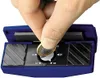 A hand is holding a coin over a blue sharpening tool with markings. Podgląd zdjęcia produktu