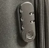 A close-up of a black combination lock on a black textured surface, likely a suitcase or bag. Produktbild-Vorschau