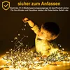 A young child is playing with a pile of fairy lights. Produktbild-Vorschau