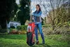 A woman is using a garden shredder in a backyard setting. Podgląd zdjęcia produktu