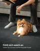 A person sitting on a couch with a dog on a carpet. Produktbild-Vorschau