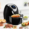 A black air fryer is shown on a kitchen counter with various foods around it, including skewers, stuffed peppers, and small pastries. Podgląd zdjęcia produktu