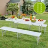 A white folding table and two benches set up for a picnic in a backyard with food and drinks on the table. Náhľad obrázku produktu