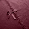 A close-up view of a red Christmas tree skirt with decorative stitching and a small bow with a button. Náhled obrázku produktu