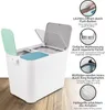 A white recycling bin with two compartments, one with a mint green lid and the other with a teal lid, is shown on a wooden floor. Text and circular graphics highlight product features. Náhľad obrázku produktu