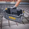 A person's hand wearing a glove is holding a black DeWalt tool carrier over a grid of rebar on a concrete floor. Podgląd zdjęcia produktu