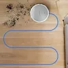 A robot vacuum cleaner is shown cleaning a wooden floor, with a trail of dirt behind it and a blue line indicating its path. Anteprima dell’immagine prodotto