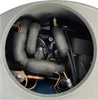 A close-up view of the internal components of a heat pump, showing insulated pipes, a motor, and copper tubing. Produktbild-Vorschau