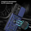 A blue rugged phone case with a camera slider and a magnetic ring holder is shown attached to a car vent mount. Produktbild-Vorschau