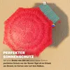 A red, fringed umbrella is shown casting a shadow on a textured surface. A striped fabric swatch is attached to the umbrella's handle. Produktbild-Vorschau