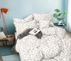 A bed with floral patterned bedding, a blanket, and a book. Náhled obrázku produktu
