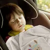 A young child sleeping in a car seat, covered by a soft blanket with a deer print. Produktbild-Vorschau