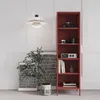 A red metal bookshelf filled with decorative items and books, standing next to framed artwork and a potted plant. Náhľad obrázku produktu