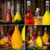 A collage of four images showing glass bottles filled with colorful liquids, some with corks, arranged with natural elements like wood and moss. Podgląd zdjęcia produktu