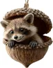 A cute raccoon peeking out of an acorn ornament. Produktbild-Vorschau