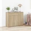 A wooden sideboard with drawers and doors, decorated with framed pictures, a plant, and a lamp on top, placed in a room with a wooden floor and a white wall. Anteprima dell’immagine prodotto