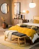 A bedroom scene with a bed, dresser, and decorative items. Podgląd zdjęcia produktu
