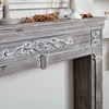 Close-up of a decorative fireplace mantel with carved details and a distressed wood finish. Anteprima dell’immagine prodotto