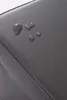 A close-up view of water droplets on a gray, textured surface, likely faux leather. Produktbild-Vorschau