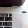 A close-up view of a laptop's keyboard and a power adapter plugged into its side. Voir les images du produit
