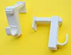 Two white curtain rod brackets are placed on a yellow background. Produktbild-Vorschau
