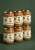 Six jars of hazelnut spread stacked in two rows against a dark green background. Produktbild-Vorschau