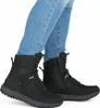 A person wearing blue jeans and black winter boots. Náhľad obrázku produktu